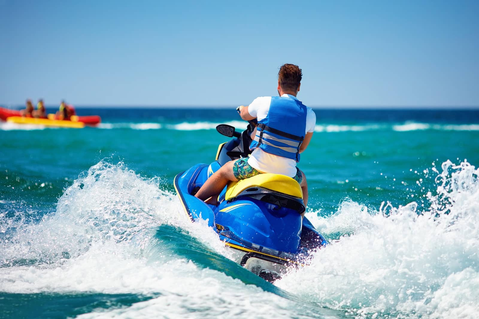 Back view of man riding jet ski