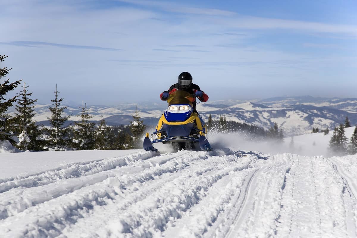 Riding snowmobile on snow covered mountains